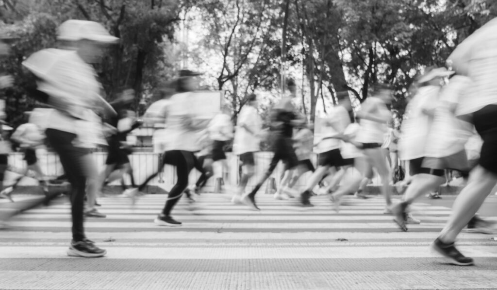 Runners races past a crosswalk in a big city marathon.